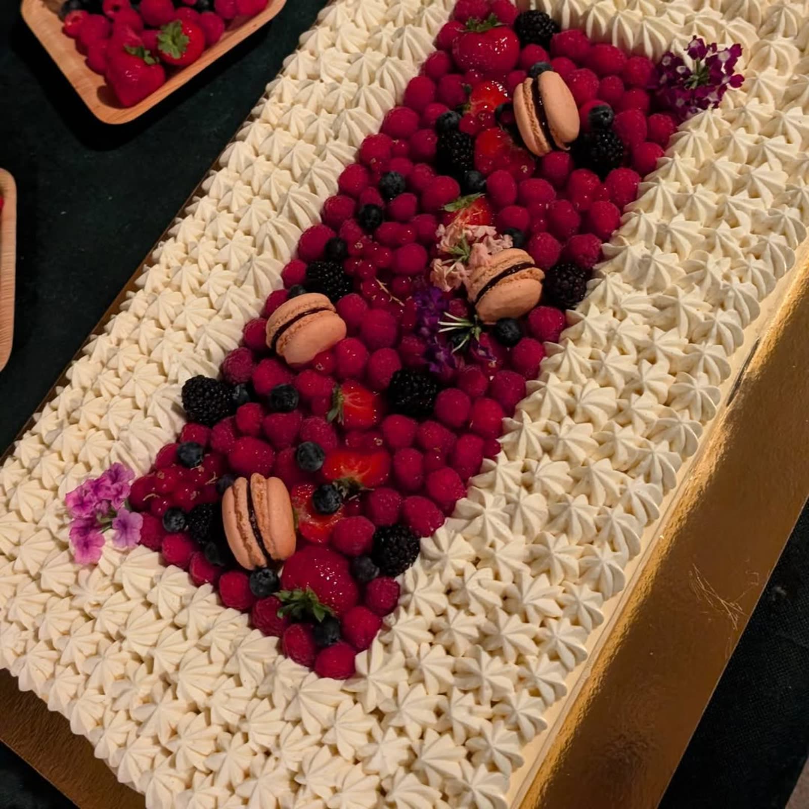 Gâteau événementiel décoré de macarons et fruits rouges